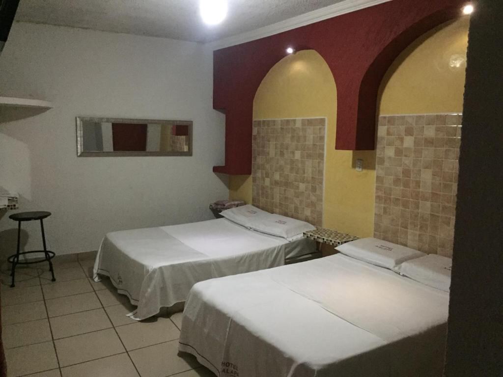 Two beds in a family room at Hotel Xalapa